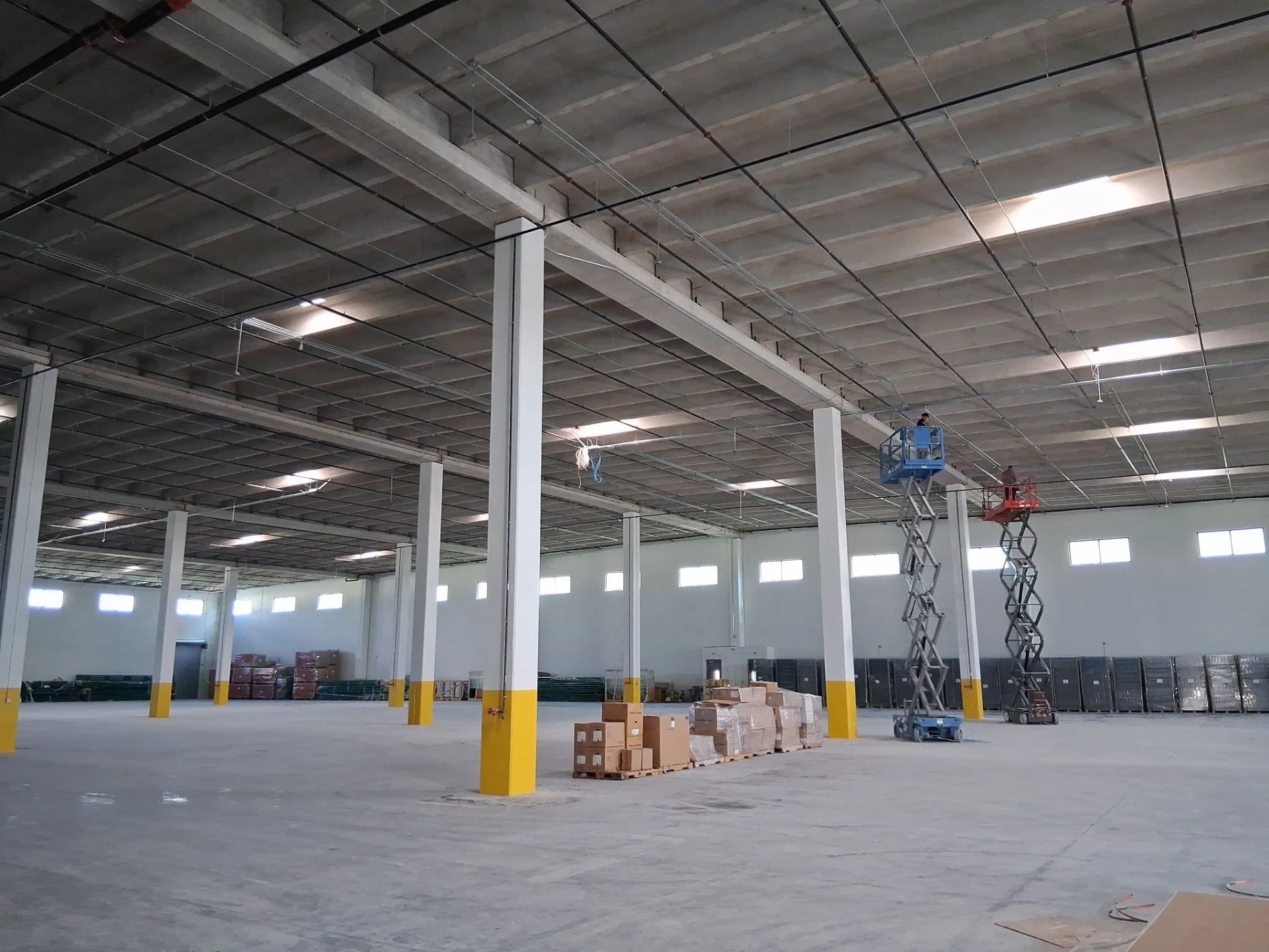 Almedia Warehouse interior construction progress with scissor lifts